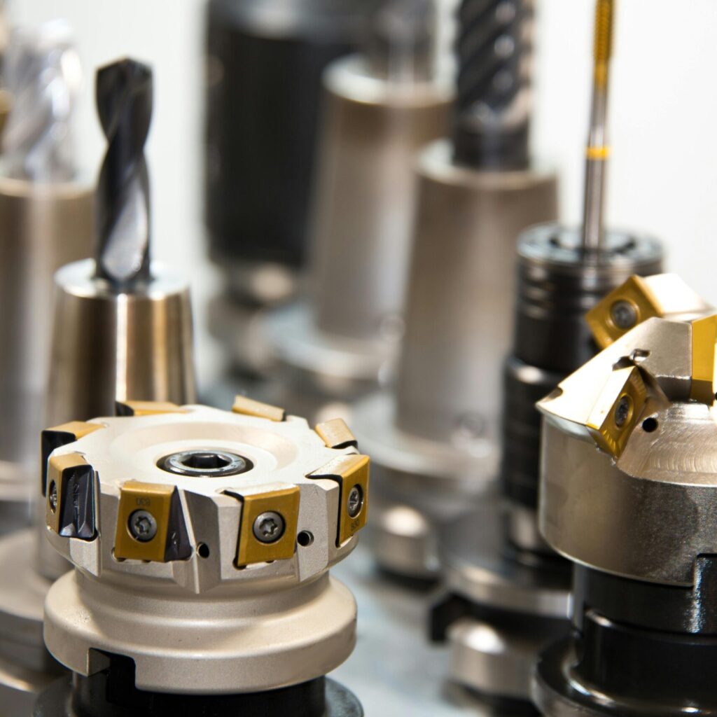 Detailed view of various metal drill bits and tools arranged in a workshop setting.
